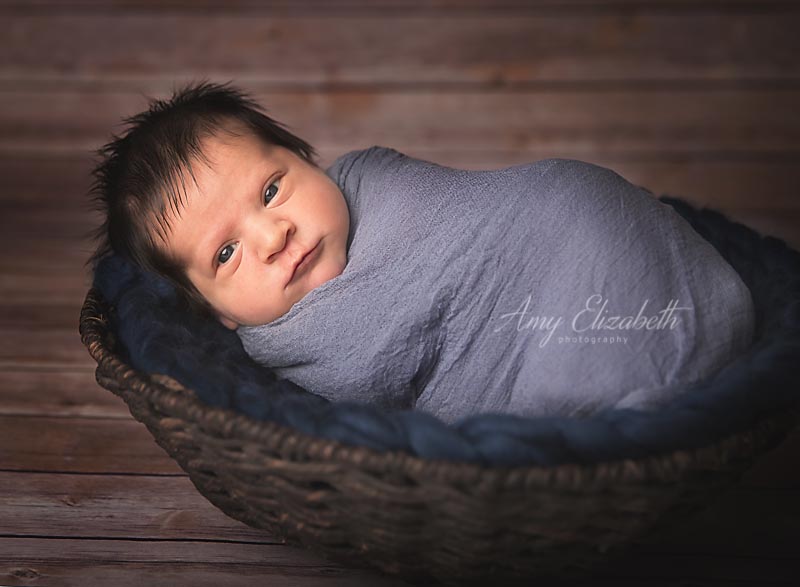 baby boy with dark hair wide awake st louis newborn photographer