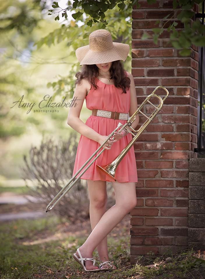 senior girl with trombone wearing hat looking down | Amy Elizabeth Photographs